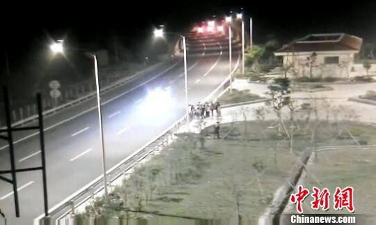 看到車輛經(jīng)過，孩子們便急忙跑到一旁的花圃上?！【焦﹫D　攝