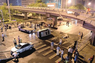路虎沖下國(guó)貿(mào)橋砸中一輛起亞轎車，橋上厚達(dá)幾十厘米的水泥護(hù)欄被撞斷，碎石四處散落，數(shù)十群眾在現(xiàn)場(chǎng)圍觀。