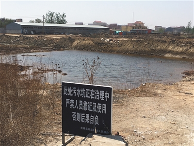 化肥廠滲坑的三分之一經(jīng)過治理，但水質(zhì)仍然呈黃褐色。