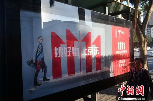 資料圖：11月1日，福州民眾從雙十一廣告牌前經(jīng)過。中新社記者 呂明 攝