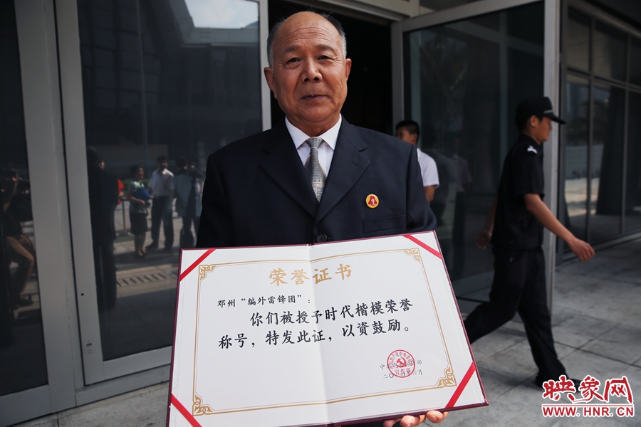 河南鄧州“編外雷鋒團(tuán)”團(tuán)長(zhǎng)宋清梅向眾多記者展示中宣部授予的“時(shí)代楷模”榮譽(yù)證書。
