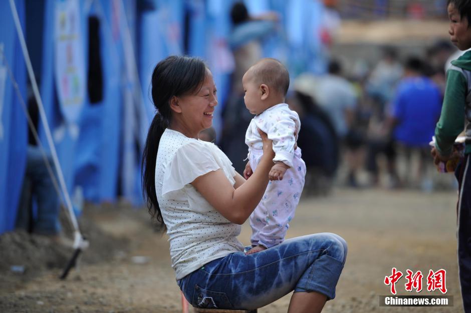 8月6日，一名年輕的母親在和孩子玩樂。