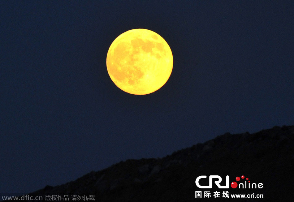 8月10日晚，一輪金燦燦的大月亮在遼寧省大連市東方升起。圖片來源：劉德斌/東方IC