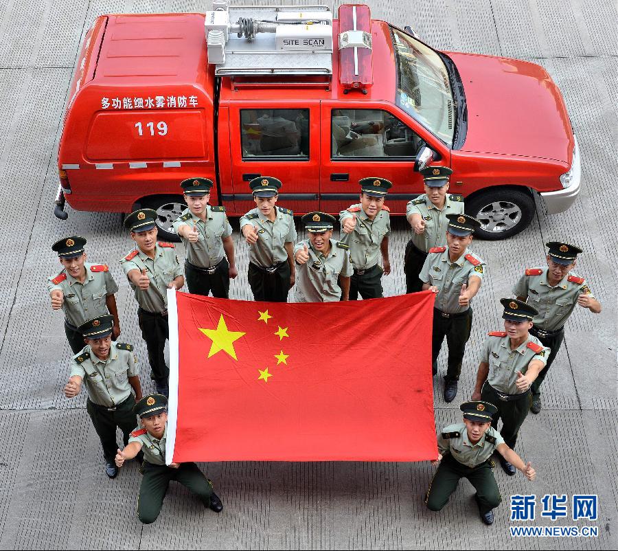  9月25日，武警浙江嘉興消防官兵與國旗合影。