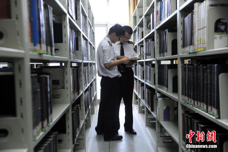 5月8日，武漢輕工大學保安吳濤與江力在圖書館交流學習。中新社發(fā) 張暢 攝
