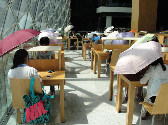 2015年8月2日，深圳圖書館，“太陽曬進(jìn)來很熱的，我們都要撐著傘讀書。”