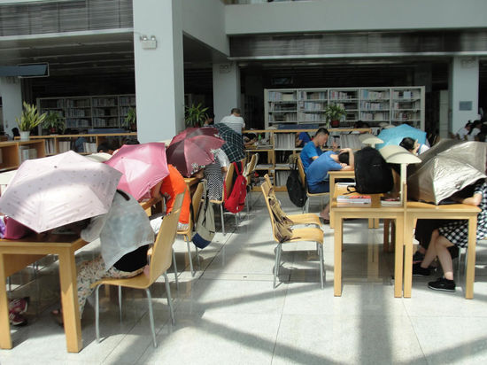 圖書館內(nèi)撐傘讀書的民眾。