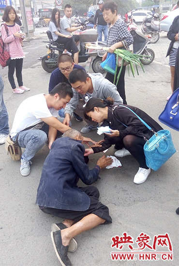 一些愛(ài)心市民在撥打了110和120后，上前給老人擦臉上的血跡。