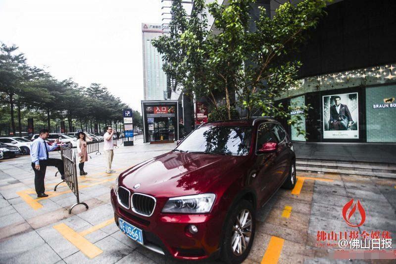一輛停在停車位上的寶馬轎車，被墜落的樹枝砸中，樹枝徑直插入車內(nèi)，現(xiàn)場(chǎng)引發(fā)不少市民圍觀拍照。