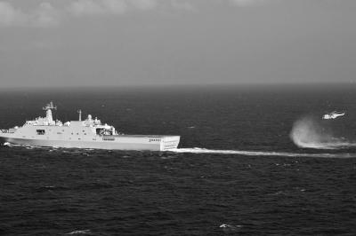 11日，抵達(dá)馬航飛機(jī)失聯(lián)海區(qū)的海軍井岡山艦與艦載直升機(jī)協(xié)同展開(kāi)立體搜救行動(dòng)。新華社發(fā)
