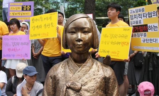 7月2日，在韓國首爾的日本駐韓國大使館前，民眾在慰安婦少女像旁手持標(biāo)語參加抗議活動(dòng)。