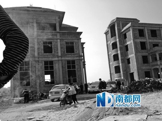 兩棟被舉報的違建樓下昨日一度聚集了超過百人，城管離開后逐漸散去。南都記者張志韜實習生宋超攝