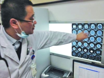 醫(yī)生在查看男孩的腦部CT片。薛馬義 攝