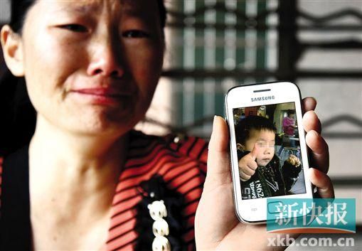 男童的舅媽拿著小益的照片,悲痛欲絕。 新快報記者 畢志毅 攝