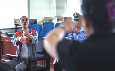 張志國(guó)在法庭上用手語(yǔ)回答提問(wèn)。記者 蒲東峰攝