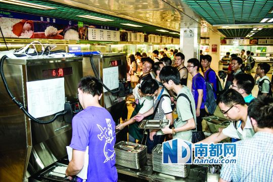 昨日，華南理工大學(xué)一食堂內(nèi)，學(xué)生們正在使用新安裝的自動打飯機打飯。中新社發(fā)