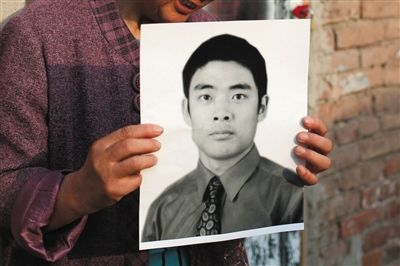 5月19日，朝陽(yáng)北路，母親捧著張東文的遺像。新京報(bào)記者 侯少卿 攝