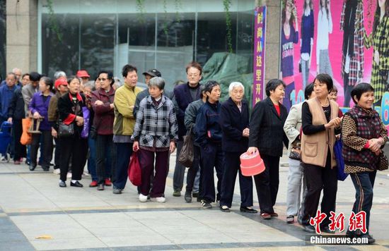 圖為10月28日，在江西九江市一家羊絨皮草服裝服飾博覽會現(xiàn)場，老人們正在頂著寒風(fēng)排隊(duì)等待領(lǐng)取10元代金劵。