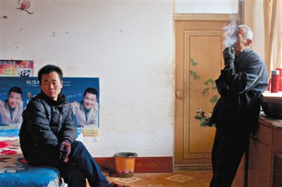 父親抽煙，兒子不語。逃跑的越南新娘，給袁迎賓父子帶來的是失落。新京報(bào)記者 周崗峰 攝