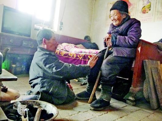 52歲的劉蘭山每天靠爬行照顧90歲的老母親。孫國(guó)祥 攝
