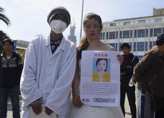 昆明火車站廣場(chǎng)上，24歲的黃習(xí)菊身穿潔白的婚紗，帶著身患白血病的弟弟征婚。