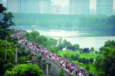 　　昨天,數(shù)萬南京市民參加“環(huán)城七十里”徒步走,圖為解放門城墻上密集的人群。 本版攝影 實(shí)習(xí)生 王甜