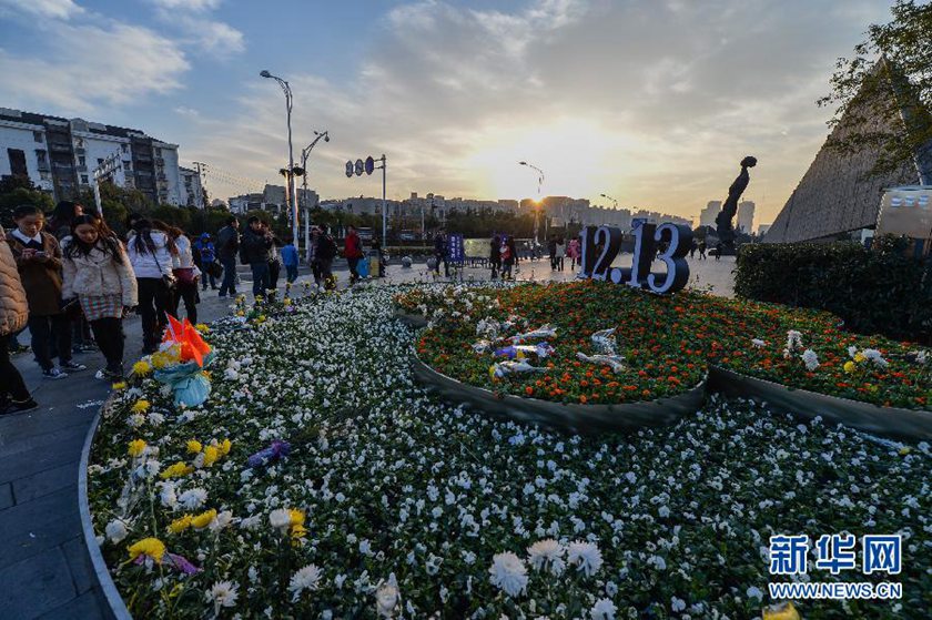 12月14日,觀眾在侵華日軍南京大屠殺遇難同胞紀(jì)念館前的“12·13”花壇上擺放鮮花祭奠遇難同胞。新華社記者 沈鵬 攝