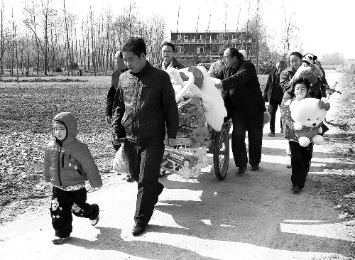姐（左一）弟（右一護士懷中男嬰）返鄉(xiāng)，愛心捐贈滿滿一架子車。