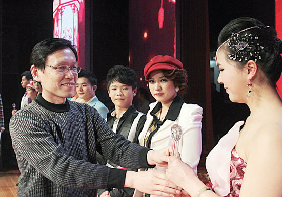 2013年2月1日，《對(duì)9當(dāng)歌》總決賽在鄭州開(kāi)唱。圖為東方今報(bào)副社長(zhǎng)胡楊為選手頒獎(jiǎng)
