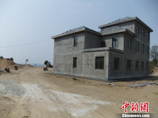 鴨河水庫(kù)庫(kù)區(qū)邊的新建別墅，一面墻上寫(xiě)著“拆”，另一邊在加緊施工。吳揚(yáng)　攝