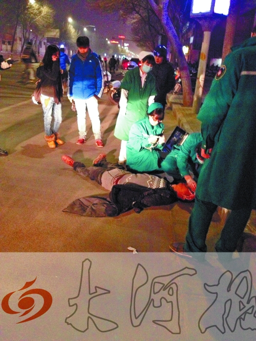 醉漢躺在地上，醫(yī)護(hù)人員對(duì)其進(jìn)行檢查。